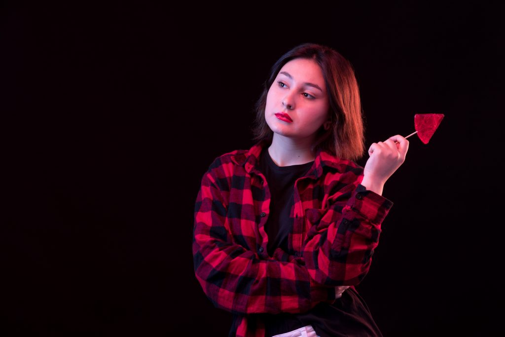 young woman posing wiht checkered red black shirt